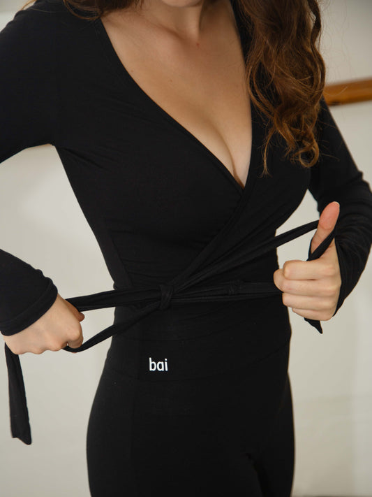 Woman wearing a tie for a wrap top in black modal. 