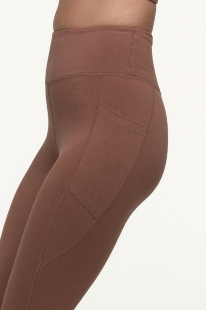 A closeup of a cappuccino brown sustainable activewear leggings high rise with focus on side pockets. #color_brown