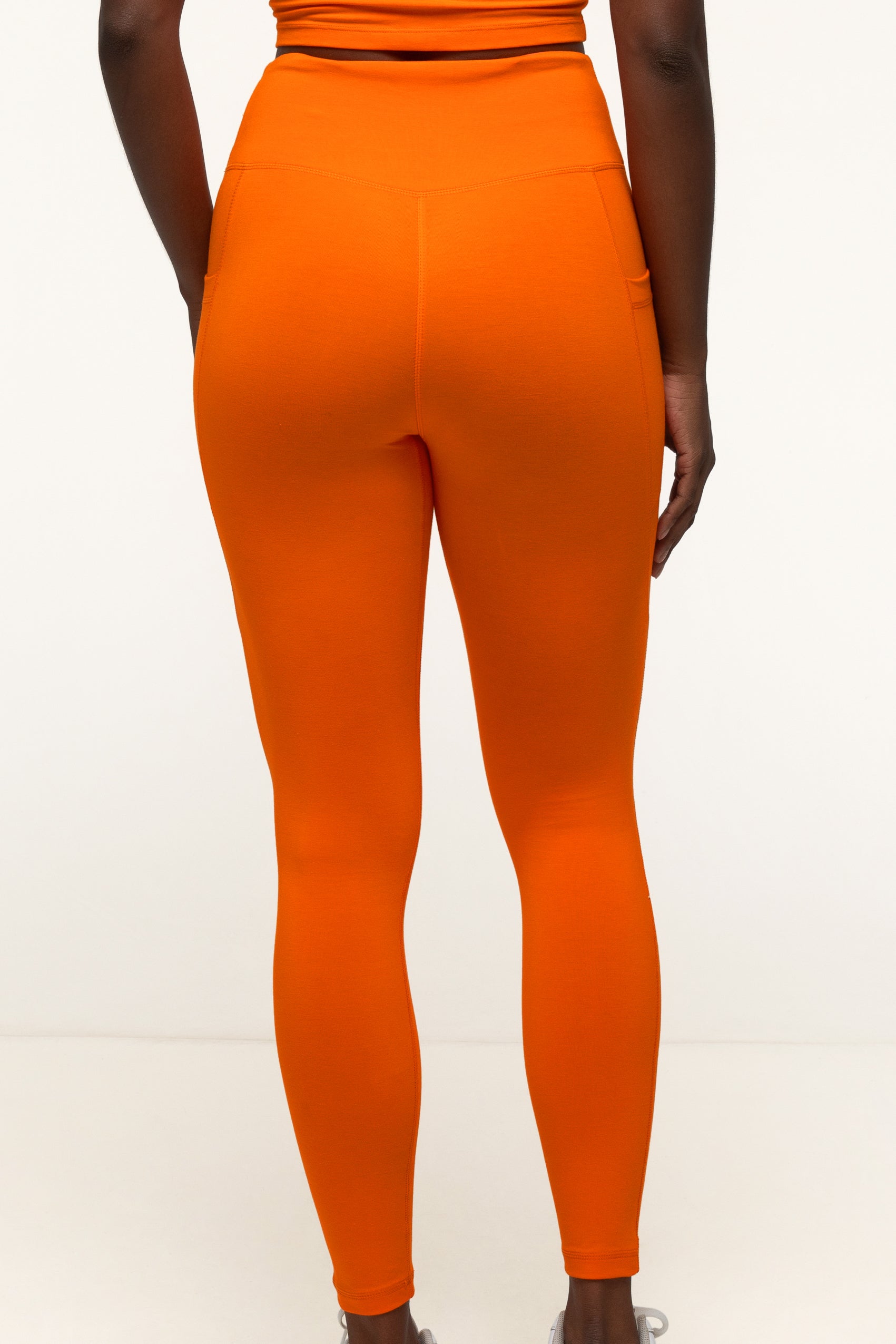 Ethically made bai active bamboo activewear set featuring high-rise soft leggings in vibrant tangerine, perfect for yoga and daily movement. #color_orange 